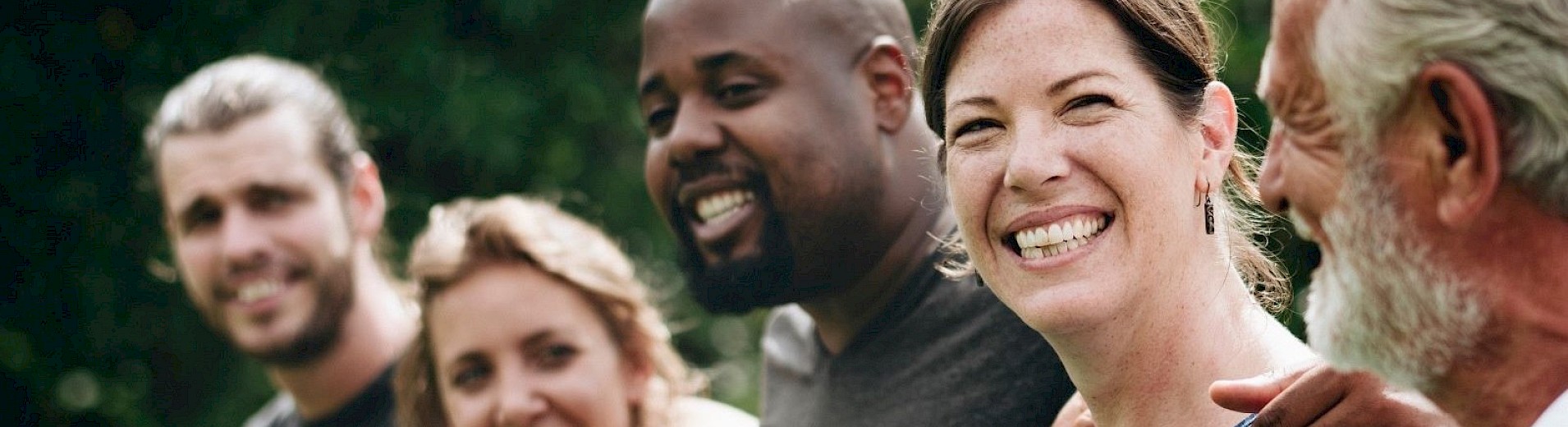 Diverse Menschen stehen in einer Reihe und umarmen sich